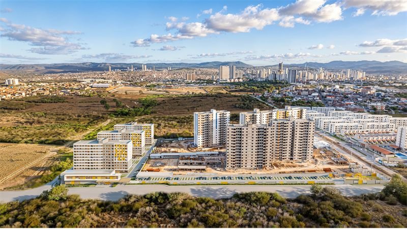 Vista aérea em 3D do condomínio Viver Bem Summer inserido no bairro, com a cidade e a serra ao fundo